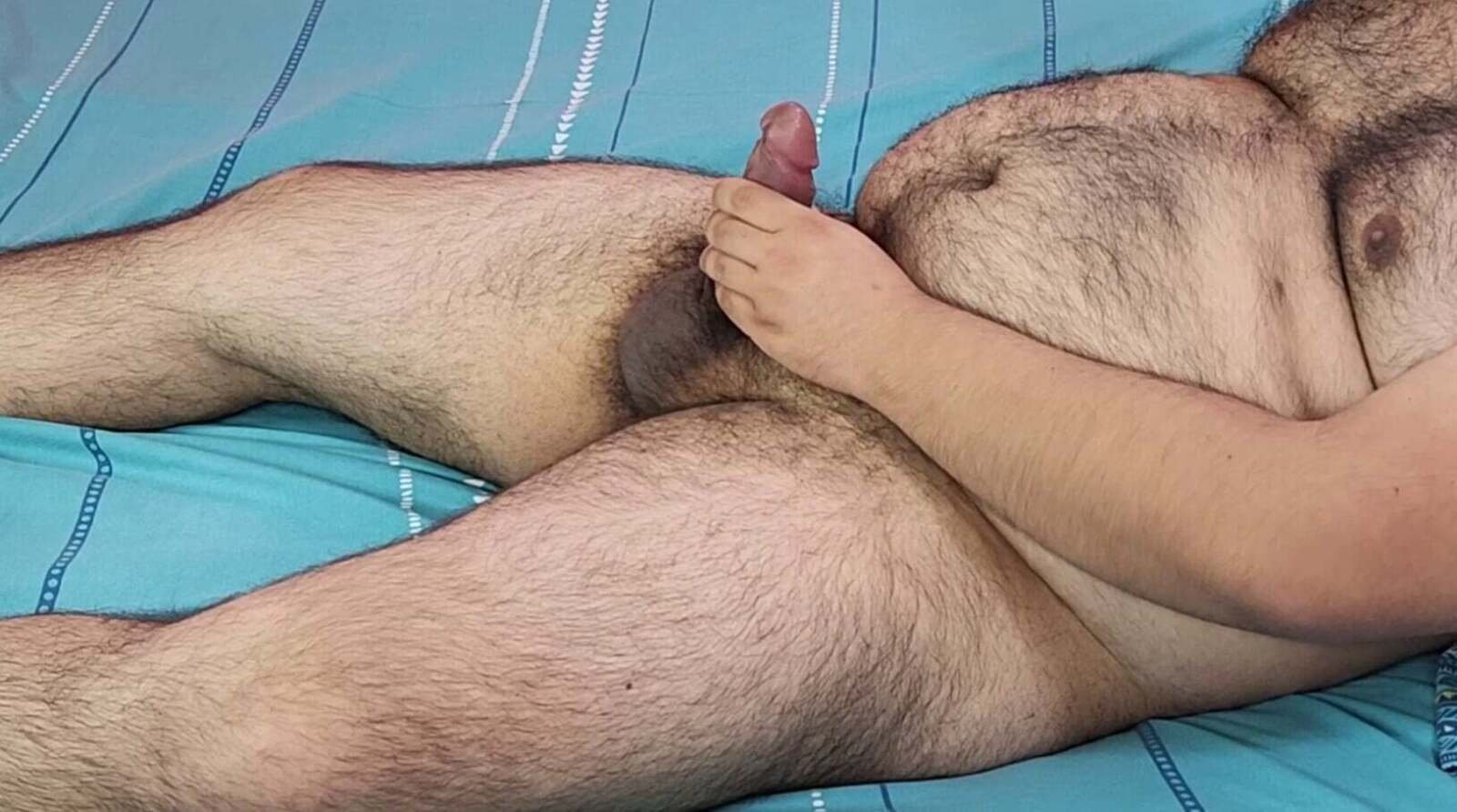 Bear man masturbating on a cyan bed